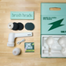 Sonic cleaning device with brush heads and packaging on a wooden surface