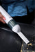 Person using a Sonic Power handheld vacuum cleaner on a dark surface with visible debris.
