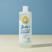Bottle of Nellie's Floor Care on a tiled floor with a blue background