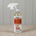 Bottle of Stain-X Pet Stain & Odor Remover on a carpet with a wooden panel background