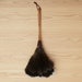 Traditional ostrich feather duster on a wooden surface