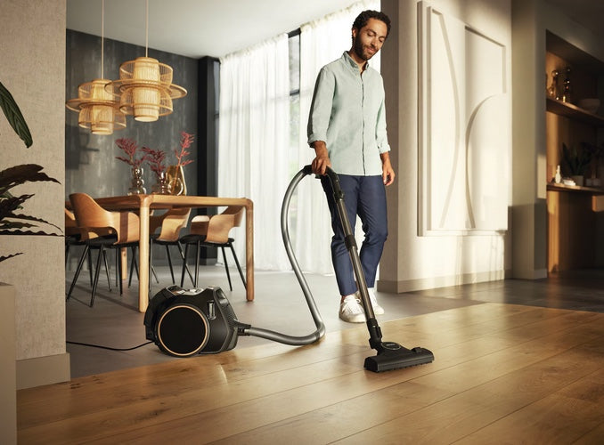 Miele Boost CX1 Lotus white SNRE0 man using vacuum in room. Capital Vacuum Raleigh Cary NC