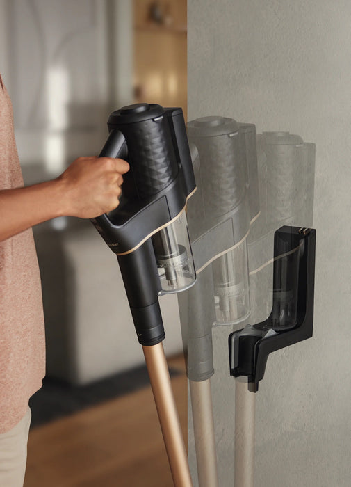Person removing Miele Duoflex HX1 Cordless Stick Broom Vacuum Cleaner Total Care, Black & Gold SQLL0 from wall mount. Capital Vacuum Raleigh Cary NC