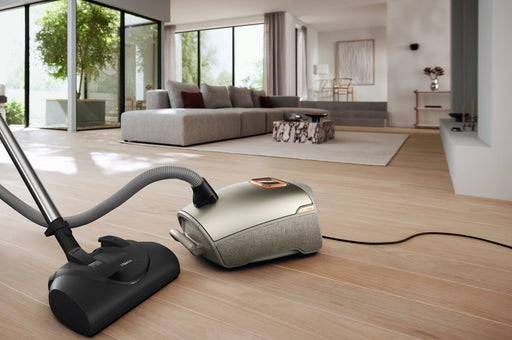 Miele Titanium PF Vacuum cleaner on a wooden floor in a modern living room. Miele Guard L1 Electro Titanium PF SUFE0 Canister Vacuum Cleaner Capital Vacuum Raleigh Cary NC