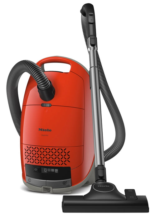 Red Miele vacuum cleaner with black attachments on a white background. Miele Guard M1 Terra Red SVWE0 Canister Vacuum Cleaner Capital Vacuum Raleigh Cary NC