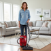 Woman using a red Miele vacuum cleaner in a living room.  Miele Homecare Classic C1  Canister Vacuum Cleaner Capital Vacuum Raleigh Cary NC