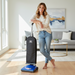 Woman standing next to a Riccar R10E vacuum cleaner in a living room. Capital Vacuum Raleigh Cary NC