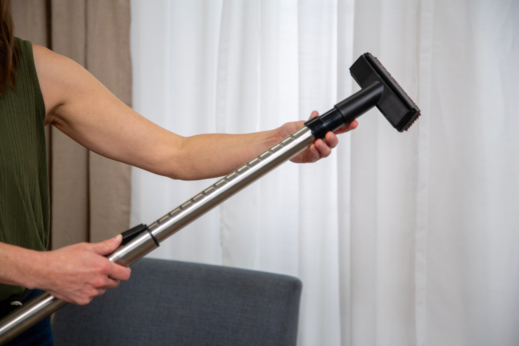 Woman holding Riccar stainless steel telescopic extension wand. Riccar R21 Spirit Plus Upright Vacuum Capital Vacuum Raleigh Cary NC