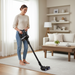 Woman using a cordless Riccar R65 vacuum cleaner in a living room. Riccar R65 cordless vacuum cleaner. Capital Vacuum Raleigh Cary NC