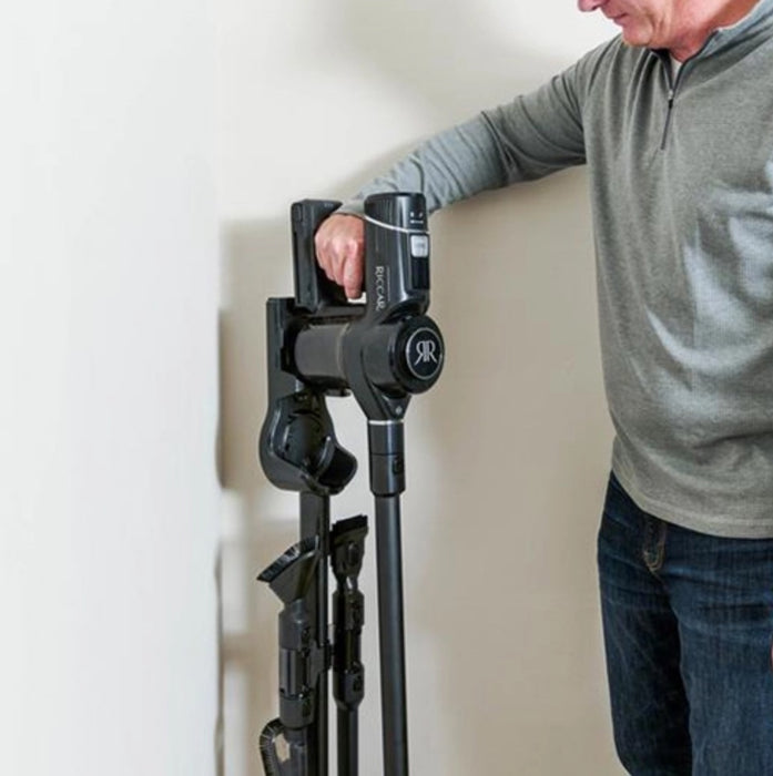 Man removing Riccar R65 cordless vacuum cleaner from stand. Capital Vacuum Raleigh Cary NC