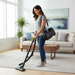 Woman using a vacuum cleaner in a living room. Black Riccar SupraQuick RSQ1. Capital Vacuum Raleigh Cary NC