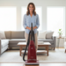 Woman standing behind a red Riccar R21 vacuum cleaner in a living room