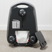 Black vacuum cleaner on a carpeted floor with a white wall in the background. Sebo Airbelt E3 Premium White Canister Vacuum 91646AM Capital Vacuum Raleigh Cary NC