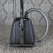 Vacuum cleaner on a carpet with patterned wallpaper in the background. Sebo Airbelt K3 Premium Blue Canister Vacuum 91698AM Capital Vacuum Raleigh Cary NC