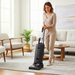 Woman using a Sebo vacuum cleaner in a living room. Sebo G4 Commercial Upright Vacuum 90406BE Capital Vacuum Raleigh Cary NC
