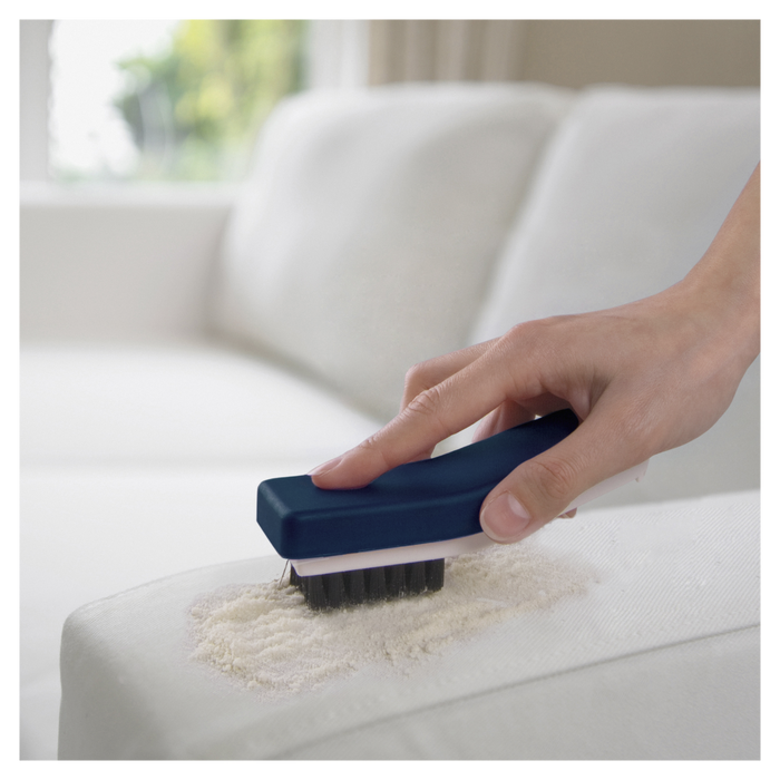 Hand using a Sebo cleaning brush on a sofa. Sebo duo Carpet Cleaner 9401AM Capital Vacuum Raleigh Cary NC