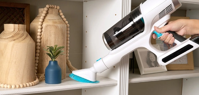Simplicity S67 handheld vacuum cleaner being used on a shelf with decorative items. Simplicity S67 cordless vacuum cleaner. Capital Vacuum Raleigh Cary NC