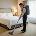 Woman cleaning a hotel room with a Titan T750 backpack vacuum cleaner.