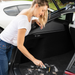 Woman using Uproot Cleaner Pro on automobile carpet. Capital Vacuum Raleigh Cary NC